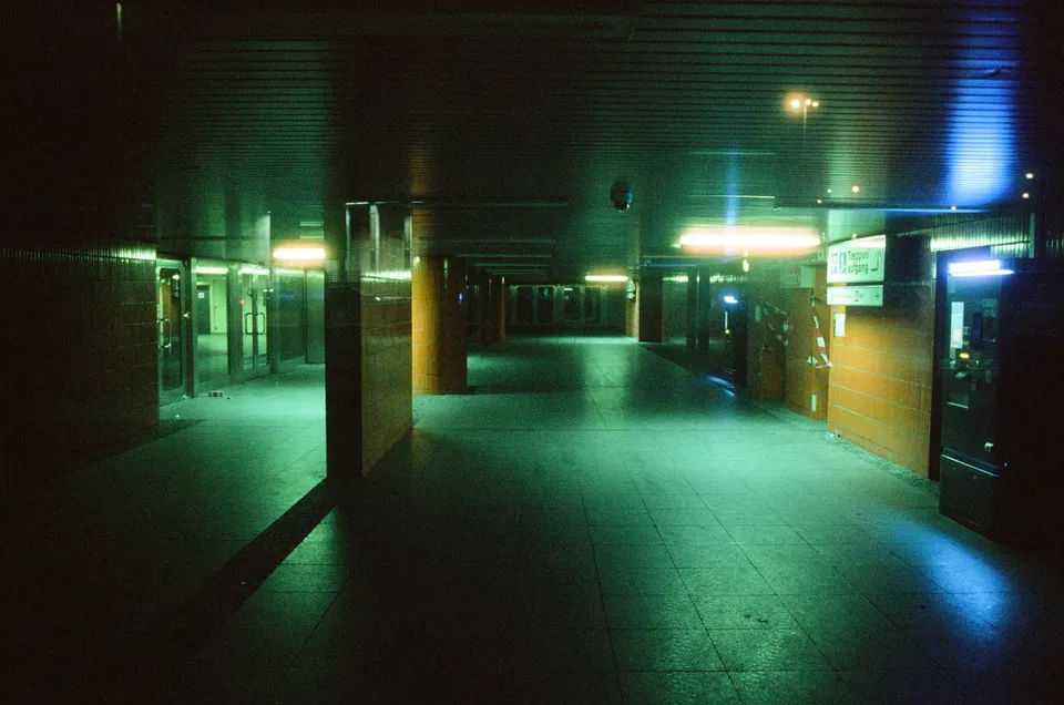 Ein beleuchtter, fliesengepflasterter Gang in einem Gebäude mit künstlichem Licht.