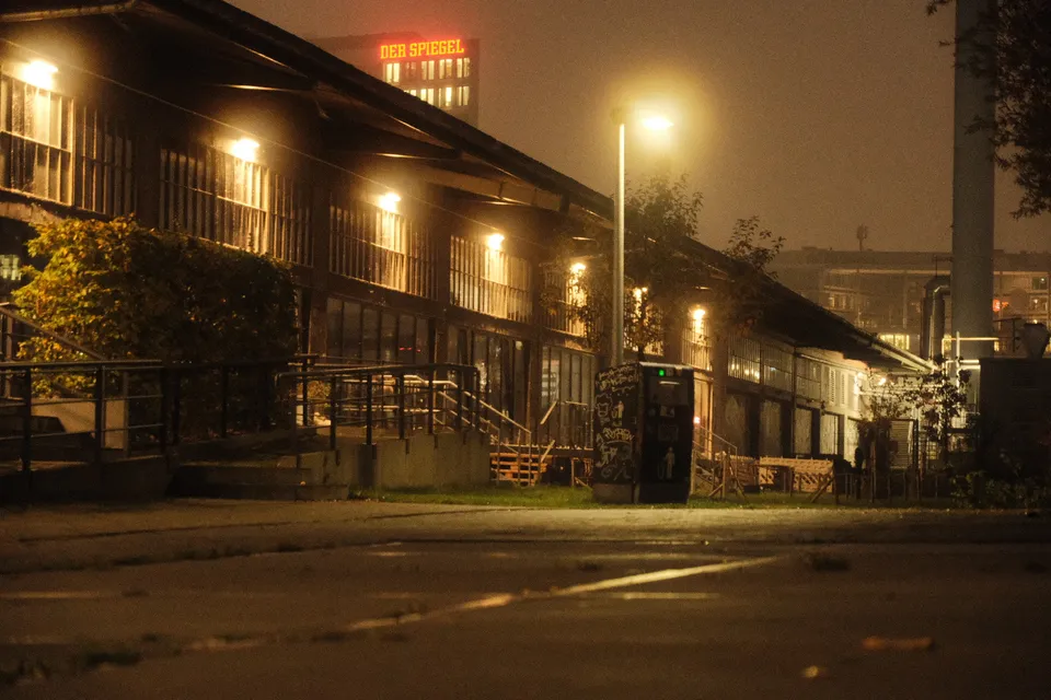 Ein langgestrecktes Gebäude mit vielen Fenstern und Außenbeleuchtung in der Nacht.